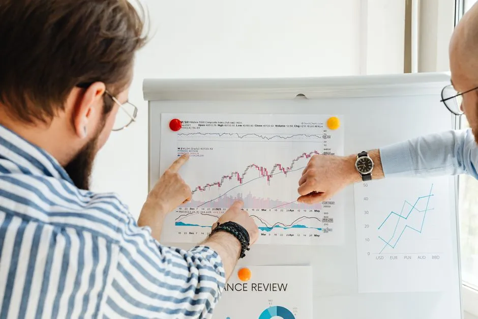 Team reviewing a business performance chart on a whiteboard during a review meeting