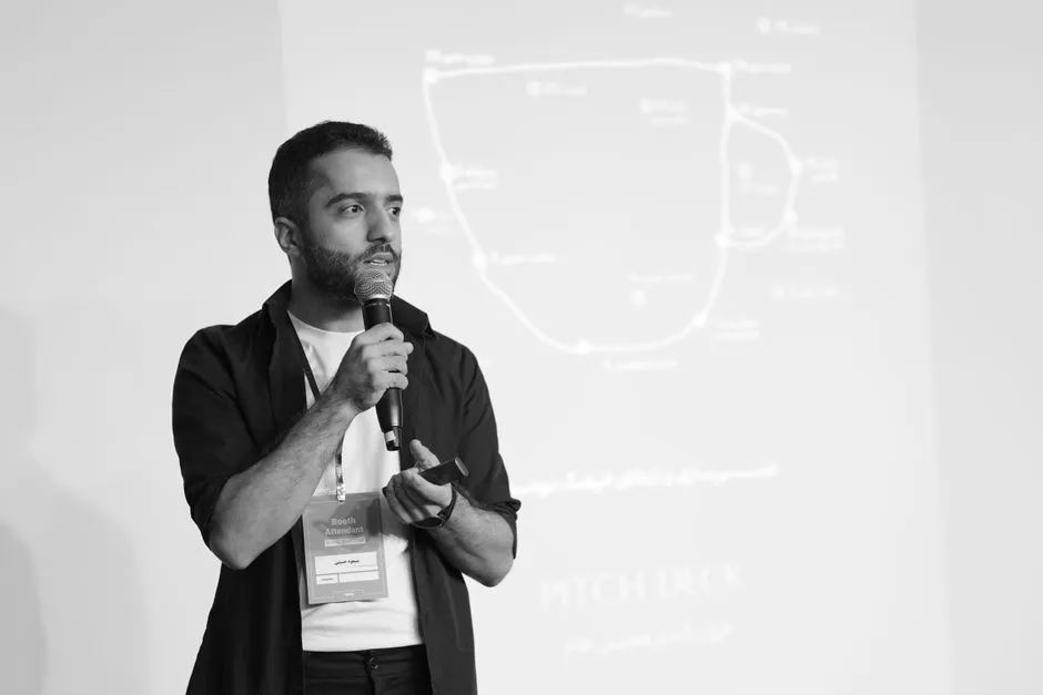 Presenter walking an audience through a pitch deck at the front of a room
